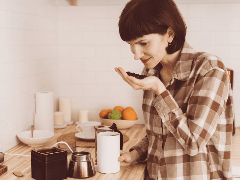 Mulher segura e cheira o café. Imagem: NataBene para Getty Images - Canva.